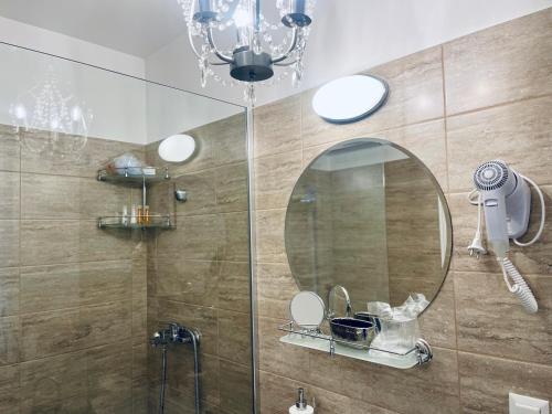 a bathroom with a shower with a mirror and a sink at Casa Cara in Târgovişte