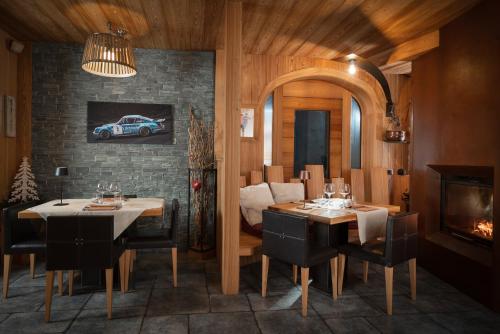 a dining room with a table and chairs and a fireplace at Alpen Hotel Chalet in Valdidentro