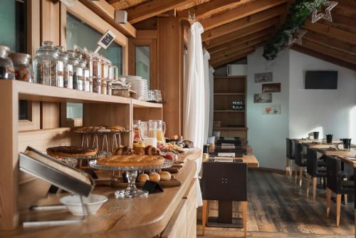 a restaurant with a counter with food on it at Alpen Hotel Chalet in Valdidentro