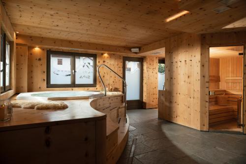 a wooden bathroom with a tub in a room at Alpen Hotel Chalet in Valdidentro