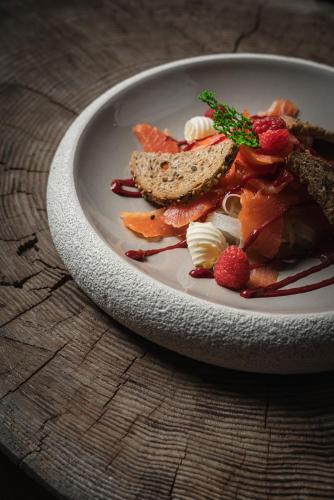 a plate of food with fruit and bread on a table at Alpen Hotel Chalet in Valdidentro