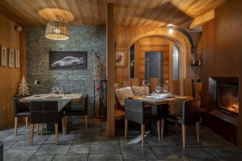 a dining room with two tables and a fireplace at Alpen Hotel Chalet in Valdidentro