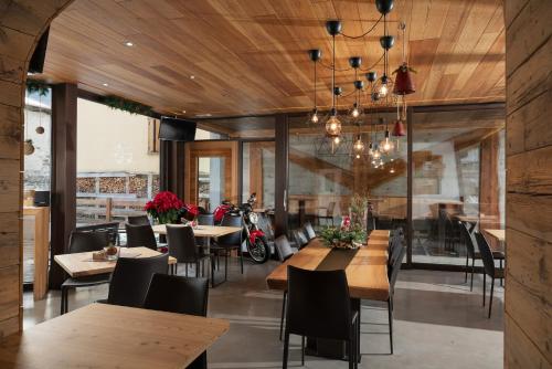 a restaurant with wooden floors and tables and chairs at Alpen Hotel Chalet in Valdidentro