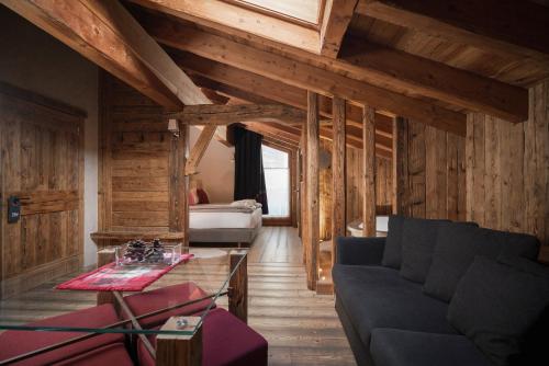 a living room with a couch and a bed at Alpen Hotel Chalet in Valdidentro