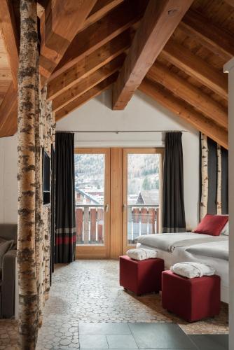 a bedroom with a bed and a large window at Alpen Hotel Chalet in Valdidentro