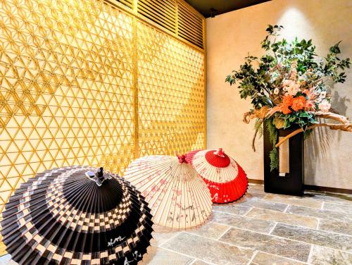 two umbrellas sitting on a floor next to a wall at ひがし茶屋街らしく金沢 Hotel Rashiku kanazawa in Kanazawa
