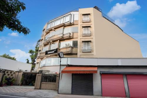 a tall building with red doors on a street at Super Townhouse Oak Rajpur Road Dehradun in Dehradun