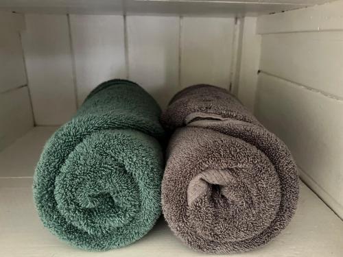 two rolls of towels sitting on a shelf at Cozy 3BR Wooden Retreat in Suva