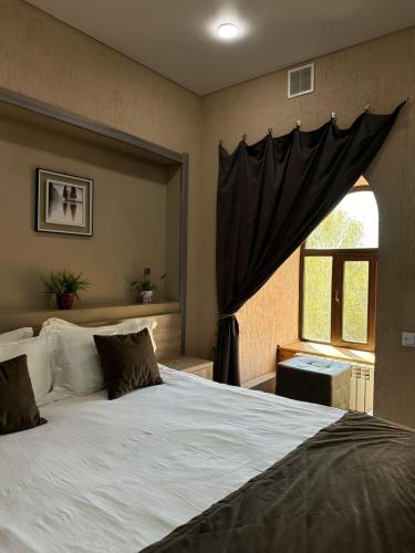 a bedroom with a large bed and a window at Deluxe SPA-Hotel in Ustʼ-Kamenogorsk