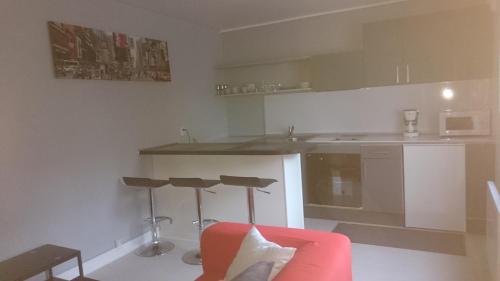 une cuisine avec un canapé rouge et un comptoir dans l'établissement F3 meublé proche gare, à Amiens