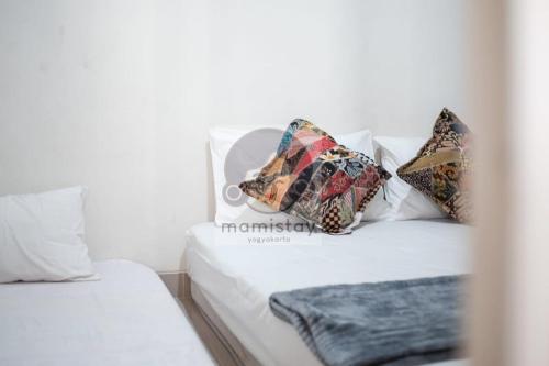 a white bed with pillows on top of it at Safiyya House Wirobrajan by Mamistay in Yogyakarta
