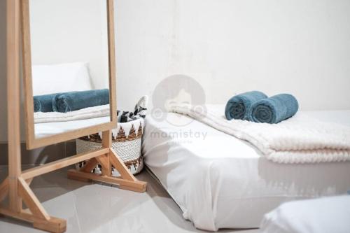a bedroom with a mirror and towels on a bed at Safiyya House Wirobrajan by Mamistay in Yogyakarta