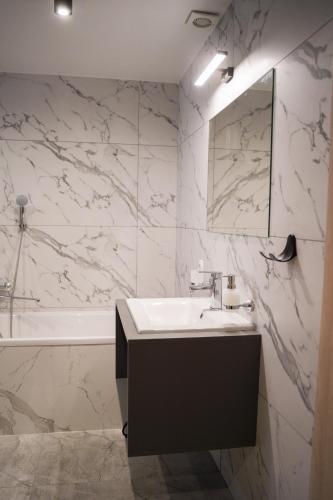 a white bathroom with a sink and a bath tub at Млин готель-ресторан-спа in Tyapche