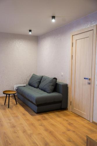 a couch in a room with a table and a door at Млин готель-ресторан-спа in Tyapche