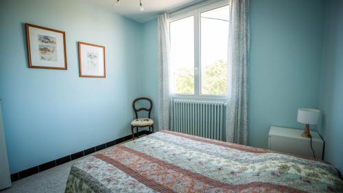 une chambre bleue avec un lit et une fenêtre dans l'établissement Mas - 12 pers - Piscine - Grand Jardin Arboré, à Ruoms