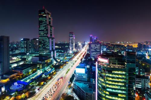 a city lit up at night with traffic at Eliena Hotel Seoul Gangnam in Seoul