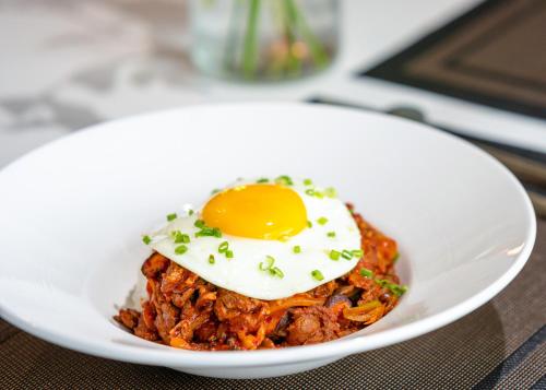 a bowl of food with an egg on top at Eliena Hotel Seoul Gangnam in Seoul