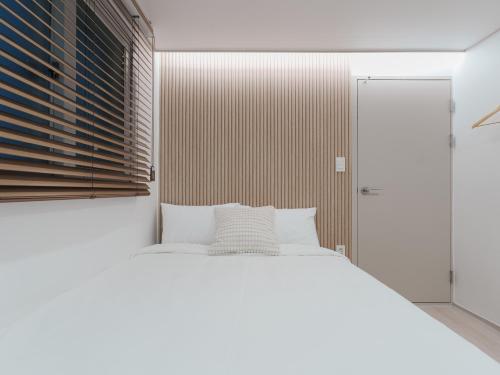 a bedroom with a white bed and a window at Elly stay in Seoul