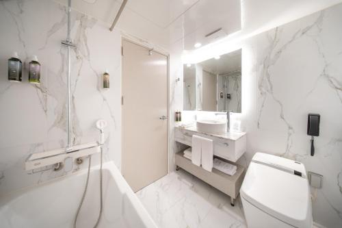 a white bathroom with a toilet and a sink at Eliena Hotel Seoul Gangnam in Seoul