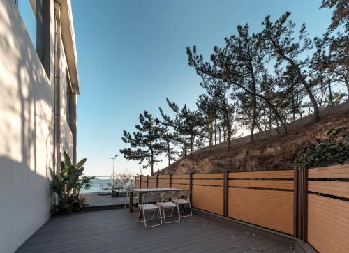 a wooden deck with a table and chairs on it at Qingdao Wushe Yujianshanju Tangchi Seaview Hotel in Qingdao