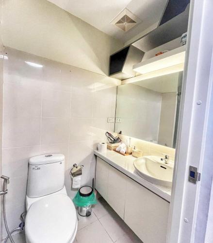 a bathroom with a toilet and a sink and a mirror at Casa de Amor in Kaybagal