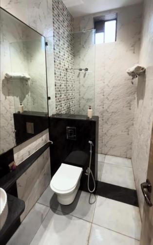 a bathroom with a toilet and a shower and a sink at Farmstay Fusion in Shamshabad
