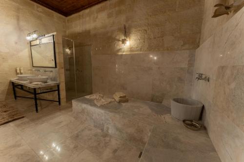 a large bathroom with a sink and a shower at Asmalı Konak Cave Suites in Urgup