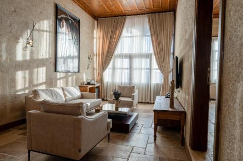 a living room with a couch and a table at Asmalı Konak Cave Suites in Urgup