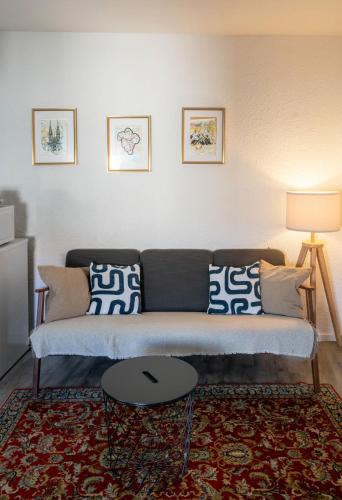 un salon avec un canapé et une table dans l'établissement La Grande Maison Clermont - Appartements centre ville, à Clermont-Ferrand