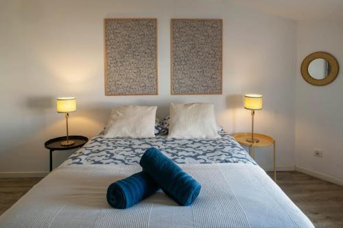 une chambre avec un grand lit avec deux lampes dans l'établissement La Grande Maison Clermont - Appartements centre ville, à Clermont-Ferrand