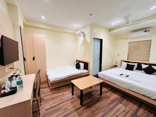 a hotel room with two beds and a table at Golden Square - Kolkata Airport in Kolkata