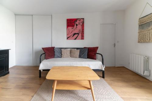 a bedroom with a bed and a wooden table at Grande Maison Clermont - Appartements centre ville in Clermont-Ferrand