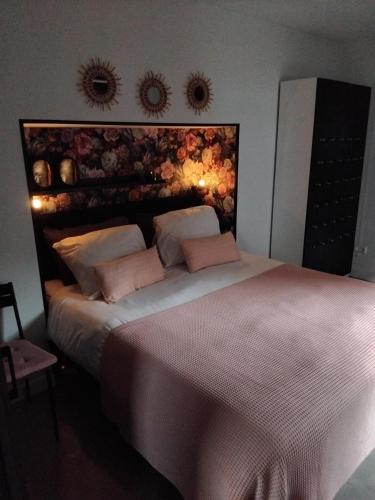 a bedroom with a large bed with two pink pillows at Ruunerwoldse Stekkie met eigen badkamer in Ruinerwold
