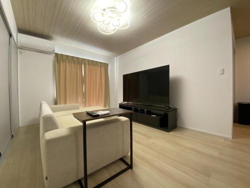 a living room with a couch and a flat screen tv at Hirari Nagahama - Vacation STAY 60207v in Chikugo