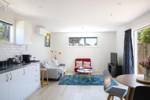a kitchen and living room with a couch and a table at Classy Modern Unit close to Airport, Shops and Bus in Christchurch