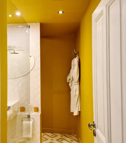 a bathroom with a shower and a yellow wall at Maison Dauphine in Aix-en-Provence