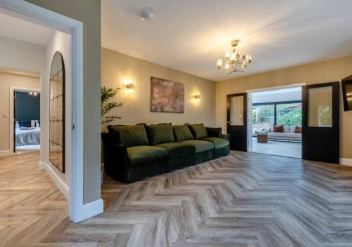 a living room with a green couch on a wooden floor at Newly Renovated luxury seaside property with hot tub - near to Cromer & Sheringham in West Runton