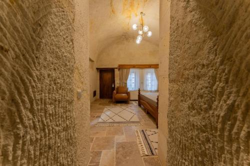 a hallway leading to a room with a bed and a window at Asmalı Konak Cave Suites in Urgup