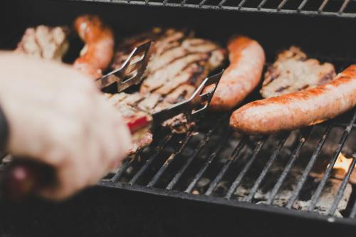 a group of sausages and meat on a grill at Hakone Villa in Hakone