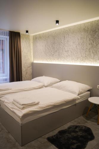 a bedroom with a large bed with white sheets at Млин готель-ресторан-спа in Tyapche