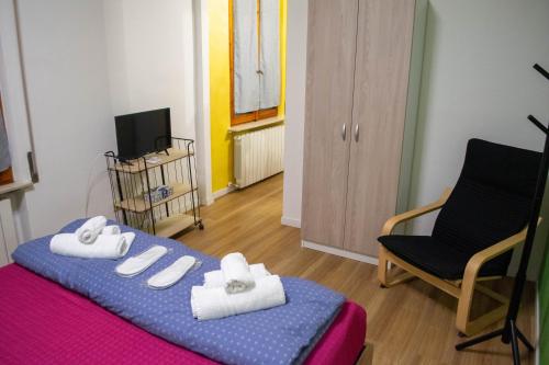 a room with a bed and a chair and a television at Maruffi 17 zona clinica bilocali in Piacenza