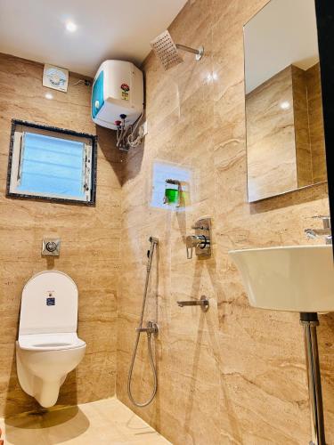 a bathroom with a toilet and a sink at Golden Square - Kolkata Airport in Kolkata