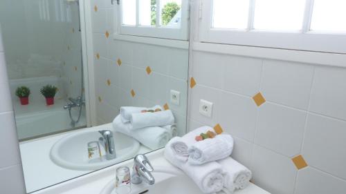 a white bathroom with a sink and a mirror at Maison familiale a 700m de la plage de Kervillen in La Trinité-sur-Mer