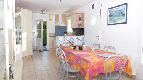 une cuisine avec une table et des chaises dans une pièce dans l'établissement Les Courlis, maison de vacances proche des plages, à Erdeven