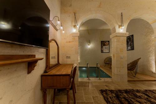 a room with a pool with a table and a sink at Asmalı Konak Cave Suites in Urgup