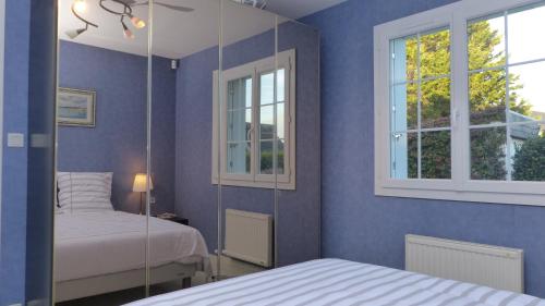 une chambre avec deux lits et un miroir dans l'établissement Les Courlis, maison de vacances proche des plages, à Erdeven
