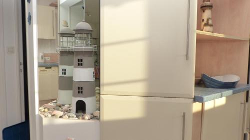 un réfrigérateur dans une cuisine avec un phare. dans l'établissement Les Courlis, maison de vacances proche des plages, à Erdeven