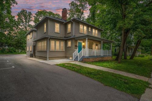 a house on a street with a driveway at Chic Remodeled Retreat Near EMU- Easy Commute apts in Ypsilanti