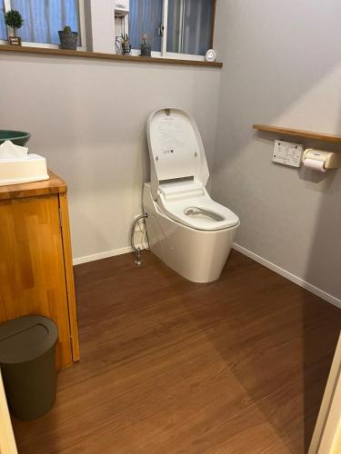 a bathroom with a toilet with the lid up at 東平乃記憶 in Niihama