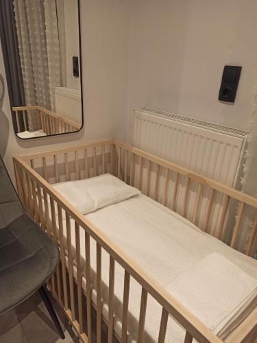 a crib in a room with a mirror and a chair at Sodi Cozy apartment in Kardítsa